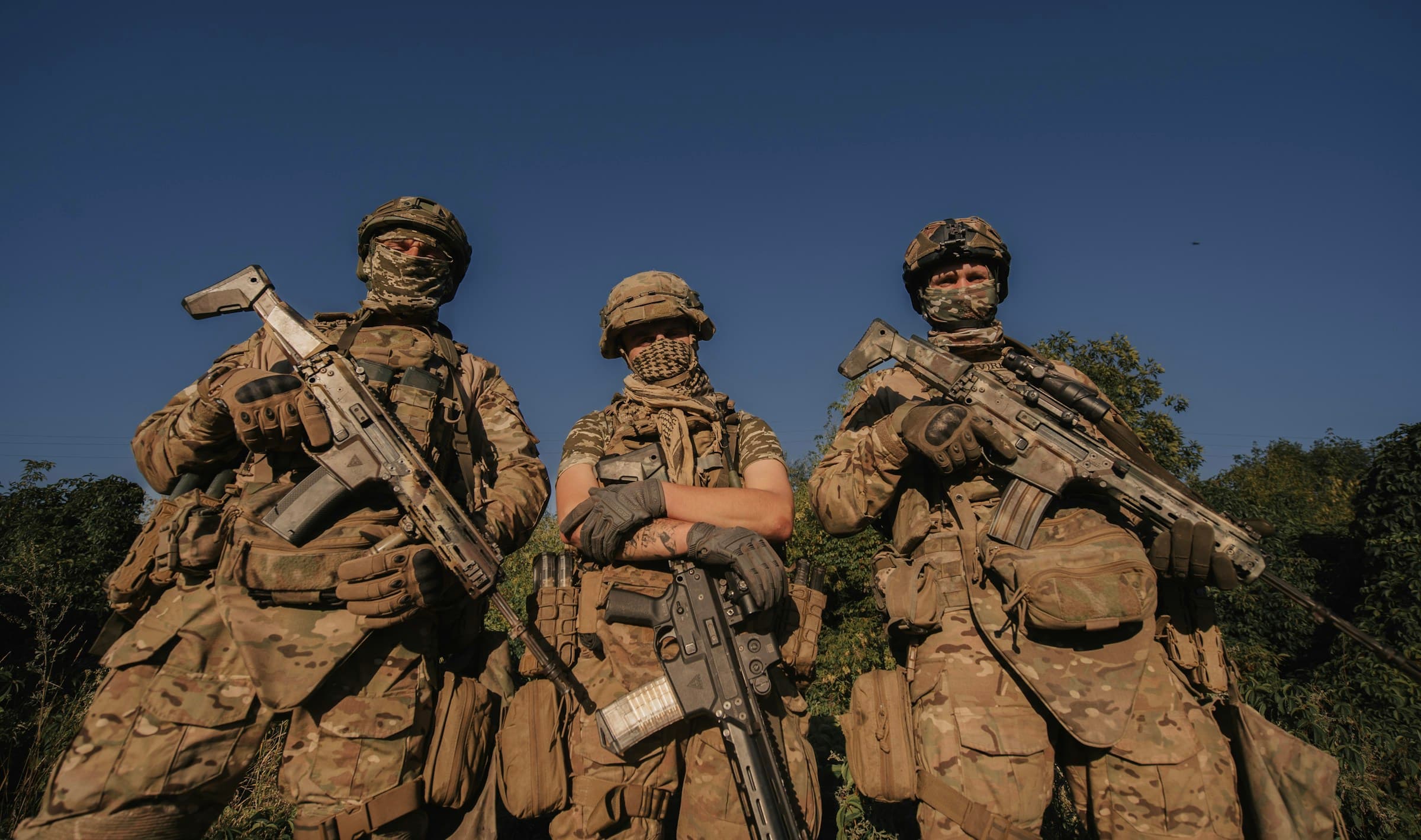 A Ukrainian squad in full kit standing ready at golden hour